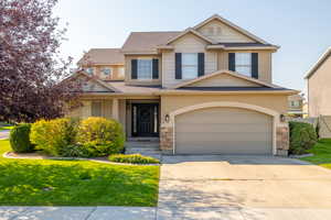 View of front of property with a garage and a front lawn