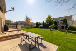 View of yard with a playground, a deck, and a patio area