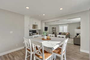 Dining room featuring light hardwood / wood-style floors and a brick fireplace