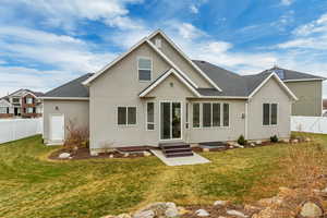 Rear view of house featuring a patio area and a lawn