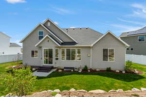 Back of property with a yard, roof with shingles, fence private yard, and stucco siding