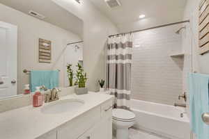 Full bathroom featuring vanity, toilet, and shower / bath combo with shower curtain