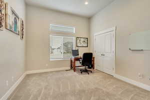 Office with light colored carpet and a high ceiling