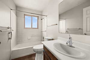 Full bathroom featuring tiled shower / bath, vanity, and toilet