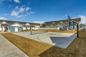 View of sport court featuring a yard, tennis court, and a playground