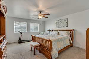 Carpeted bedroom featuring ceiling fan