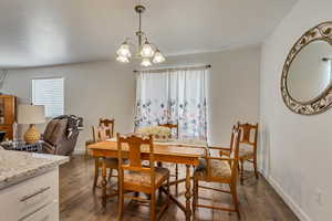 Dining area with dark hardwood / wood-style flooring and a chandelier