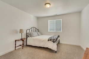 Bedroom featuring light carpet