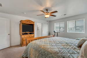 Carpeted bedroom with ceiling fan