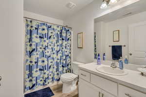 Bathroom with vanity, hardwood / wood-style floors, and toilet