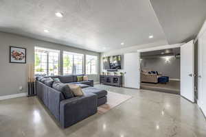 Living room with concrete flooring and a textured ceiling