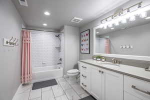 Full bathroom featuring vanity, shower / tub combo, a textured ceiling, and toilet