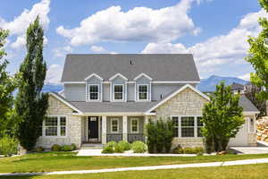 View of front of home featuring a mountain view, a garage, and a front lawn