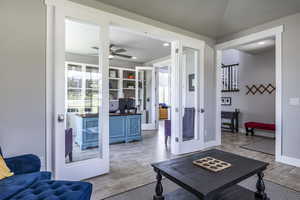 Living room featuring lofted ceiling, hardwood / wood-style floors, french doors, and ceiling fan