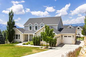 Craftsman inspired home featuring a garage, a mountain view, and a front lawn