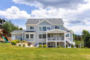 Back of house featuring a playground and a lawn