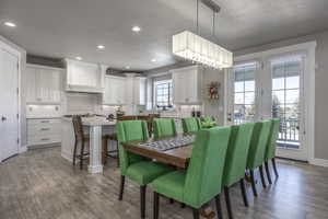 Dining area with a textured ceiling and light hardwood / wood-style floors