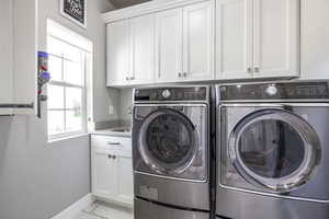 Washroom featuring cabinets and independent washer and dryer