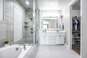 Bathroom with vanity, shower with separate bathtub, and a textured ceiling