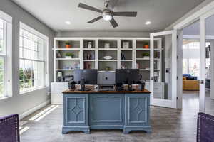 Office space featuring ceiling fan, a healthy amount of sunlight, and hardwood / wood-style floors