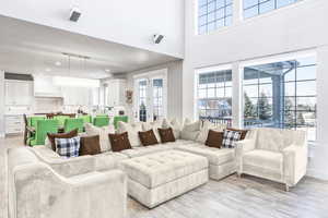 Living room featuring light hardwood / wood-style floors and a high ceiling