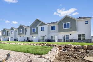 Back of property featuring a lawn and central air condition unit