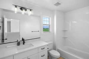 Full bathroom featuring vanity, shower / bathtub combination, and toilet