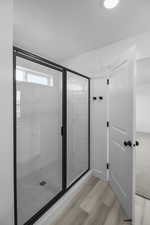 Bathroom with wood-type flooring and an enclosed shower