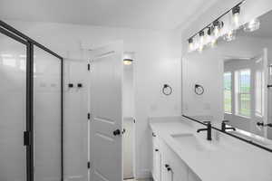 Bathroom featuring vanity and a shower with shower door