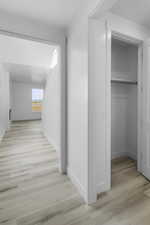 Corridor with light hardwood / wood-style flooring