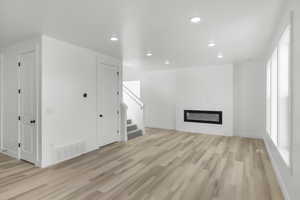 Unfurnished living room with a fireplace and light hardwood / wood-style flooring