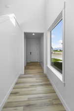 Corridor with light hardwood / wood-style flooring