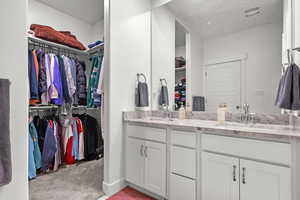 Master bathroom with double vanity attacheds to walk-in closet