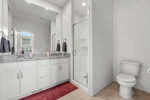 Large master bathroom featuring walk in shower, vanity, toilet, and tile patterned flooring