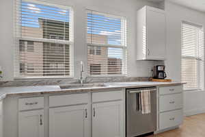 Kitchen featuring white cabinetry, sink, plenty of natural light, and dishwasher