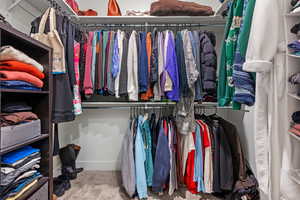 Spacious walk-in closet with carpet flooring