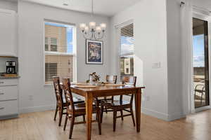 Dining space with a notable chandelier and light laminate flooring