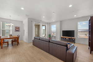 Living room with light laminate flooring opens to outdoor deck