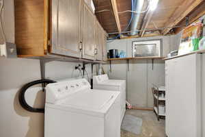 Laundry area with cabinets and washing machine and clothes dryer