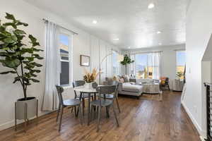 Dining space with hardwood / wood-style floors and a textured ceiling