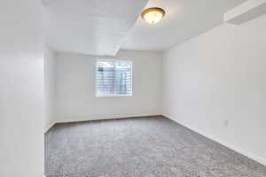 Carpeted empty room featuring a textured ceiling