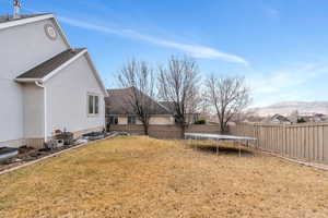 View of yard with central AC unit, a mountain view, and a trampoline