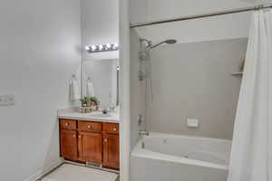 Bathroom with shower / bath combination with curtain and vanity