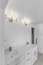 Bathroom featuring vanity, a textured ceiling, and an inviting chandelier