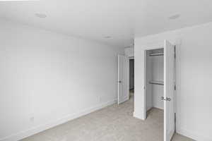 Unfurnished bedroom featuring light colored carpet