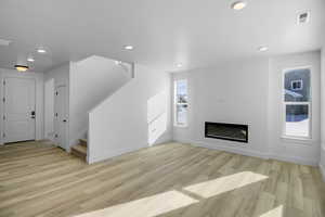 Unfurnished living room with light hardwood / wood-style floors