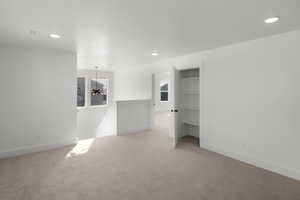 Spare room featuring light colored carpet and an inviting chandelier