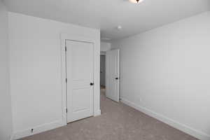 Unfurnished bedroom with light colored carpet