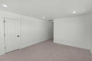 Empty room featuring light colored carpet