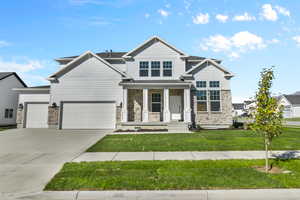 Craftsman-style house with a garage, covered porch, and a front yard